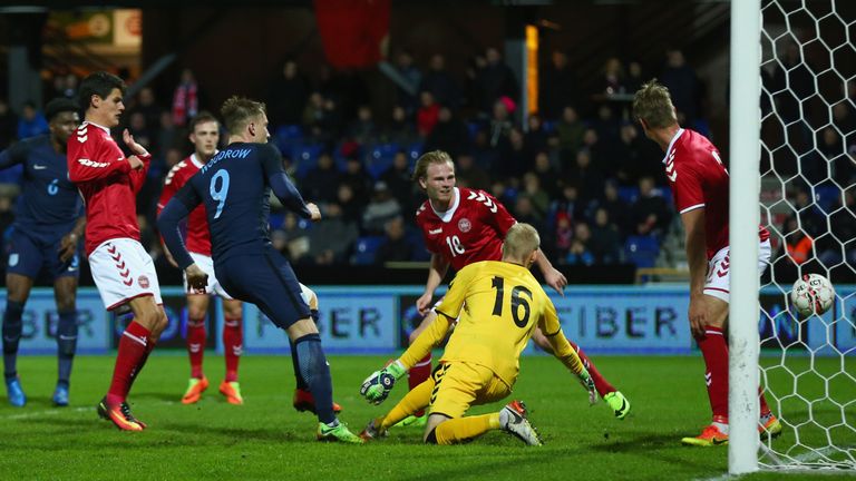 RANDERS, DENMARK - MARCH 27:  Cauley Woodrow of England (9) scores their third goal past goalkeeper Andreas Hansen of Denmark during the U21 international 