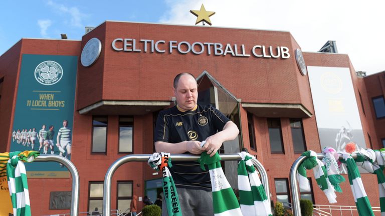 A Celtic fan lays out his scarf in tribute to Tommy Gemmell, who has died aged 73