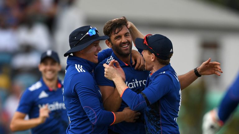 Liam Plunkett of England celebrates with teammates Eoin Morgan and Jason Roy after dismissing Jason Holder of the West Indies