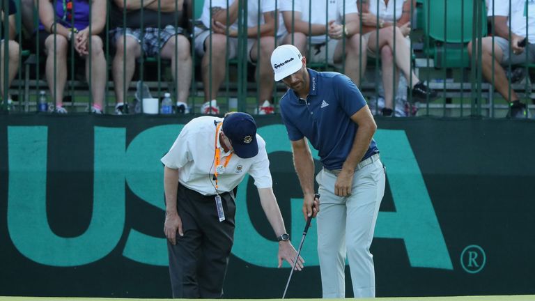 OAKMONT, PA - JUNE 19:  Dustin Johnson of the United States chats with a rules official behind the 16th green during the final round of the U.S. Open at Oa