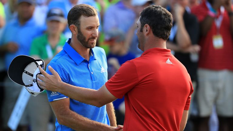 Dustin Johnson (L) shakes hands with Jon Rahm