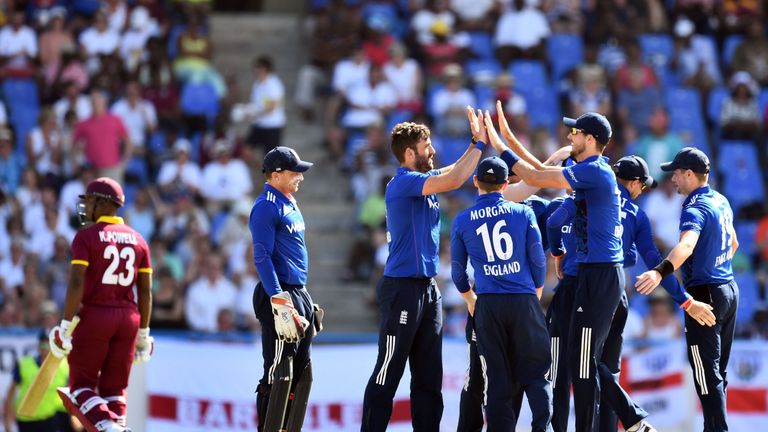 England's cricketer Liam Plunkett (C) celebrates with teammates after dismissing West Indies batsman Kraigg Brathwaite (#23) during the One Day Internation