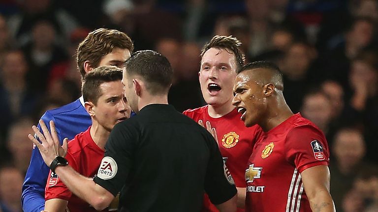 Manchester United players protest as Ander Herrera is shown a red card by referee Michael Oliver
