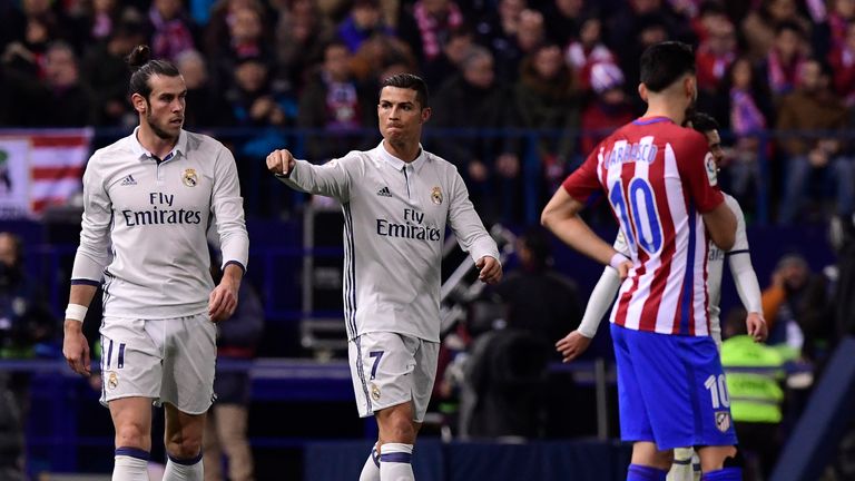 Real Madrid's Portuguese forward Cristiano Ronaldo (C) gestures beside Real Madrid's Welsh forward Gareth Bale (L) and Atletico Madrid's midfielder Carrasc