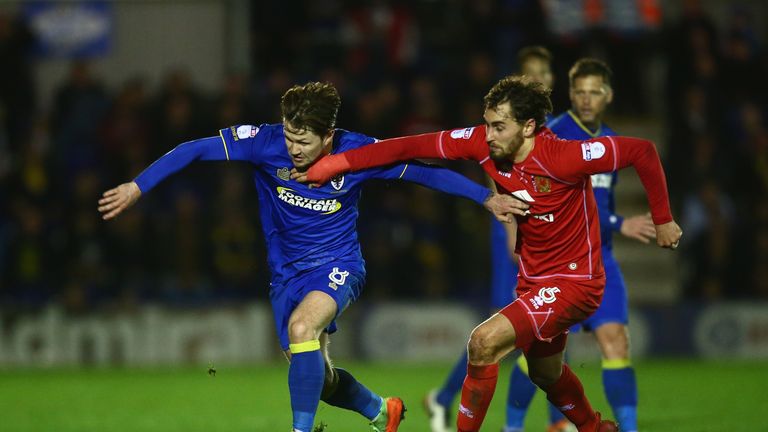 Jake Reeves is challenged by Ed Upson of MK Dons