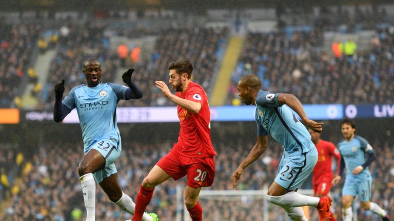 ya Toure of Manchester City (L) and Fernandinho of Manchester City (R) battle for possession with Adam Lallana of Liverpool