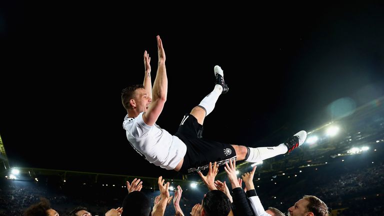 Lukas Podolski is thrown in the air by his team-mates after playing his final game for Germany