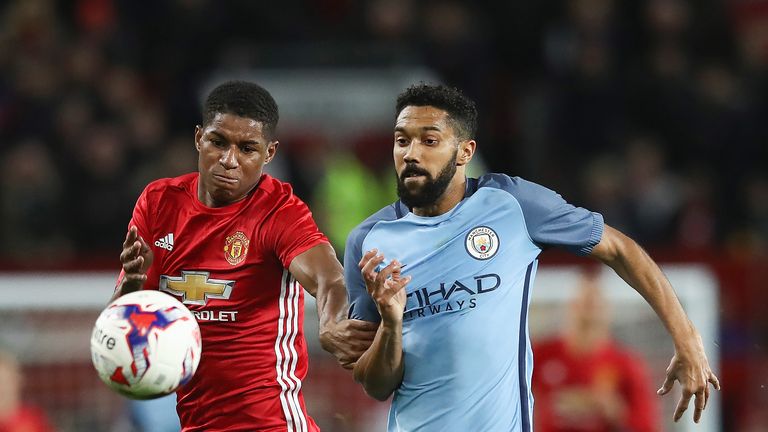 Marcus Rashford and Gael Clichy challenge each other for possession during the EFL Cup Fourth Round