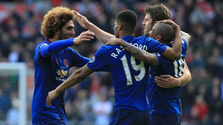 Manchester United's Belgian midfielder Marouane Fellaini (L) celebrates with teammates after scoring the opening goal of the English Premier League footbal