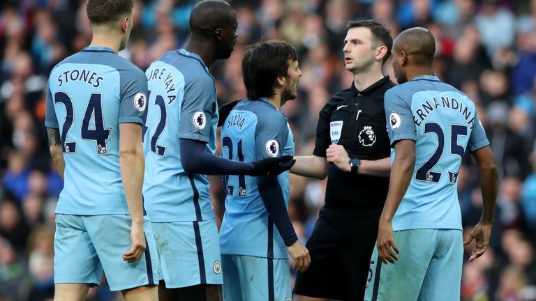 Manchester City players surround referee Michael Oliver after the Liverpool penalty during the Premier League match at the Etihad Stadium