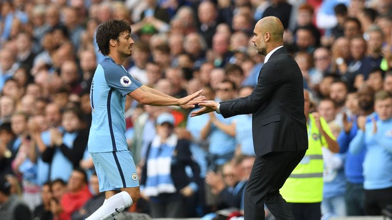 Manchester City's Spanish midfielder David Silva (L) touches hands with Manchester City's Spanish manager Pep Guardiola (R) as Silva is sustituted during t