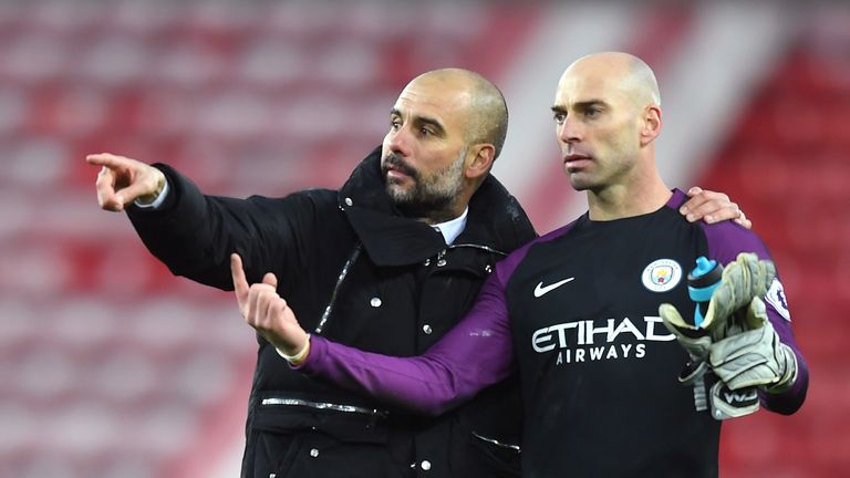 Pep Guardiola speaks to Willy Caballero on the pitch after Man City's win over Sunderland