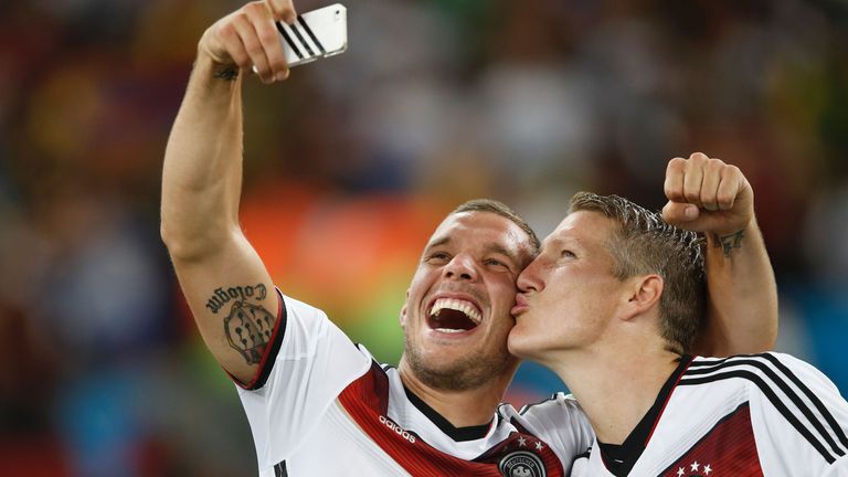 Bastian Schweinsteiger (R) and team-mate forward Lukas Podolski  take a 'selfie' after their World Cup win
