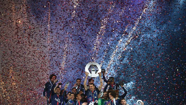Paris Saint-Germain's Swedish forward Zlatan Ibrahimovic holds the trophy on the podium after winning the French L1 title