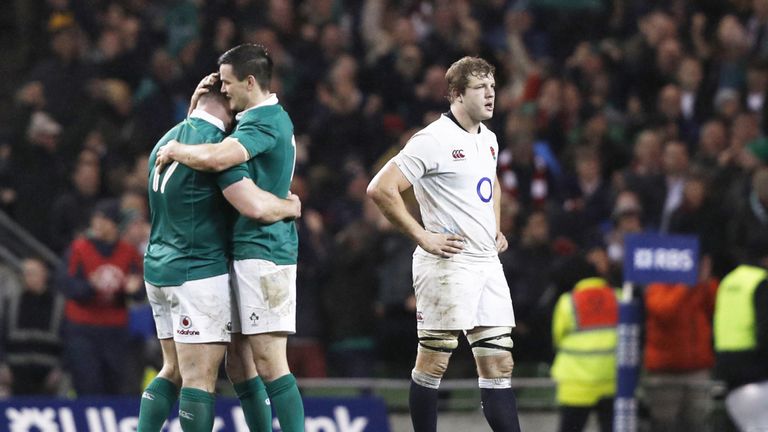Cian Healy (L) andJohnny Sexton embrace as England's lock Joe Launchbury reacts after the final whistle