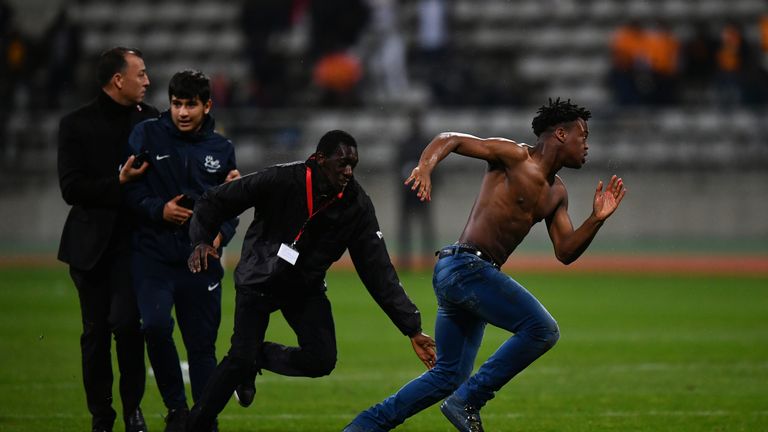 PARIS, FRANCE - MARCH 27:  Pitch invaders are tackled by security during the International Friendly match between the Ivory Coast and Senegal at the Stade 