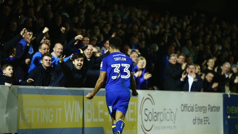 Lyle Taylor celebrates with the fans after scoring AFC Wimbledon's second goal