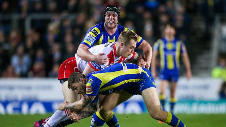 St Helens' Adam Swift is tackled by Warrington's Daryl Clark and Chris Hill