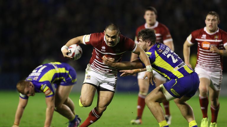 Wigan Warriors' Thomas Leuluai is tackled by Warrington Wolves' Joe Philbin, during the Betfred Super League match at the Halliwell Jones Stadium