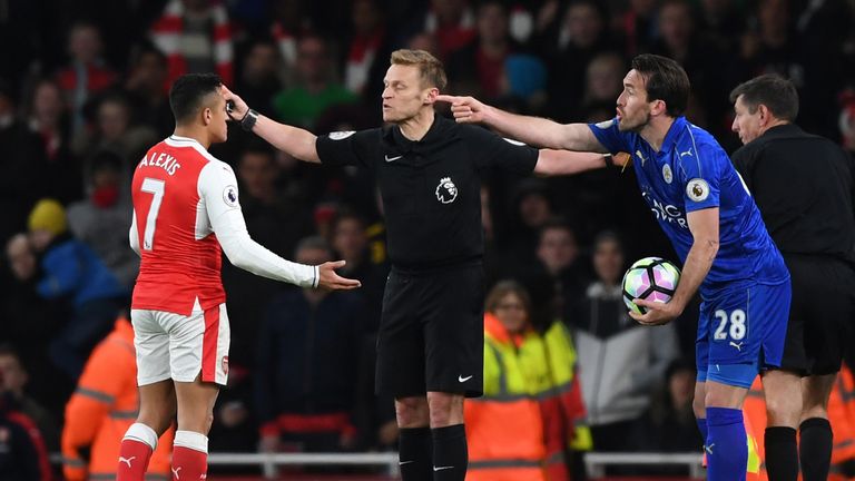 Referee Mike Jones stands between Sanchez and Leicester's Christian Fuchs