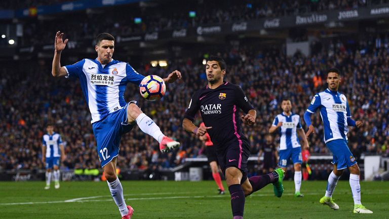 Aaron Martin of RCD Espanyol competes for the ball with Luis Suarez of FC Barcelona during the La Liga match