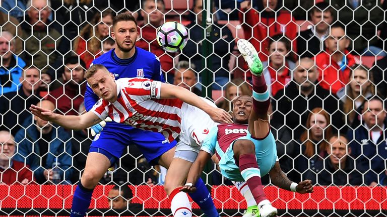 West Ham United's French-born Ghanaian midfielder Andre Ayew (R) tries an overhaed a shot, which is saved by Stoke City's English goalkeeper Jack Butland d