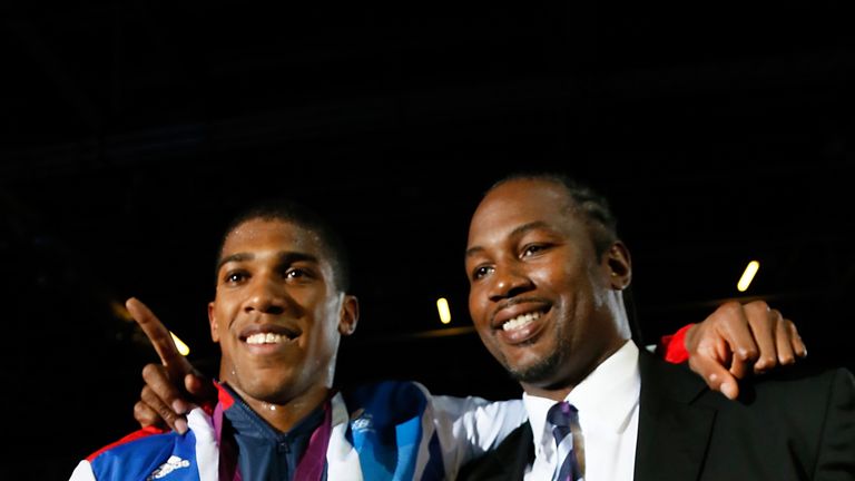Gold medalist Anthony Joshua (L) celebrates with former world heavweight boxing champion and fellow countryman Lennox Lewis (R) during the awards ceremony 