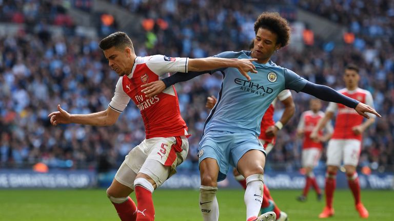 LONDON, ENGLAND - APRIL 23: Gabriel of Arsenal and Leroy Sane of Manchester City compete for the ball during the Emirates FA Cup Semi-Final match between A
