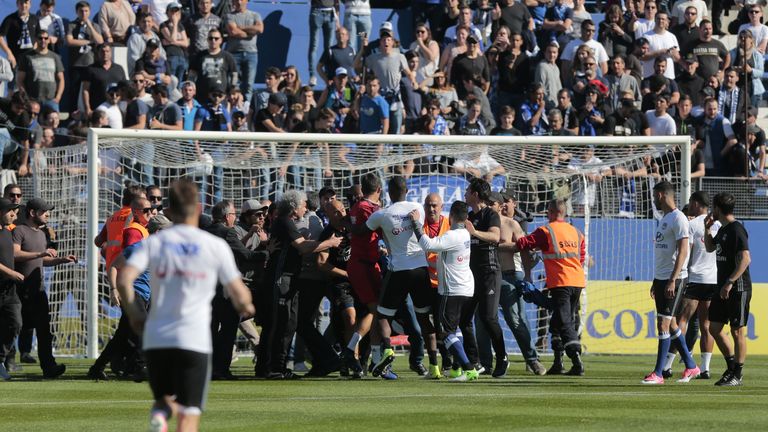 Bastia's supporters invade the pitch try to fight with Lyon players during warm up prior to the French L1 Football match between Bastia (SCB) and Lyon (OL)