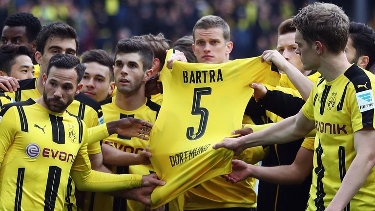 DORTMUND, GERMANY - APRIL 15: Players of Dortmund hold the jersey of their injured team mate Marc Bartra 