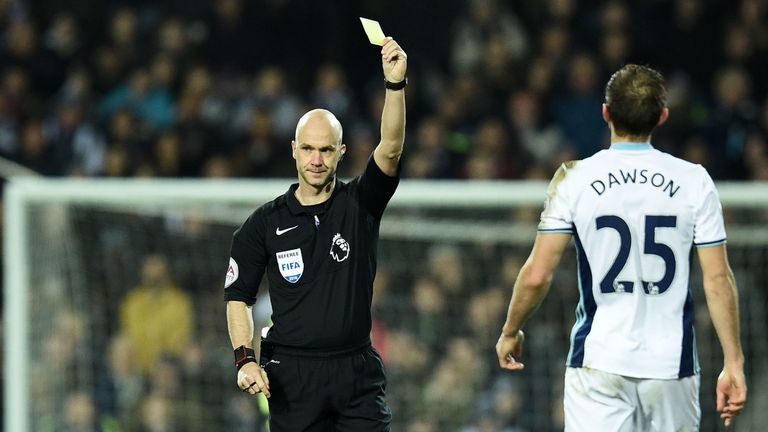 Referee Anthony Taylor shows a yellow card to West Bromwich Albion's English defender Craig Dawson (R) for a challenge on Manchester United's Swedish strik