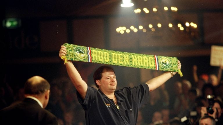Raymond Barneveld holds a scarf above his head as he walks on the stage before his match against Ronnie Baxter