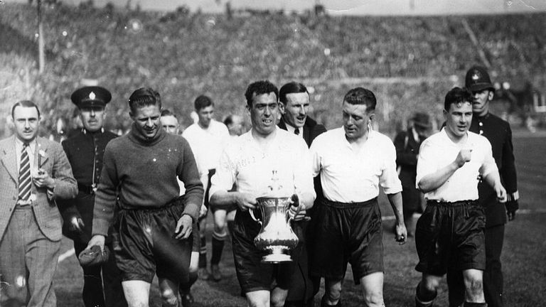 Dixie Dean (centre) carries the FA Cup on a lap of honour around Wembley in 1933
