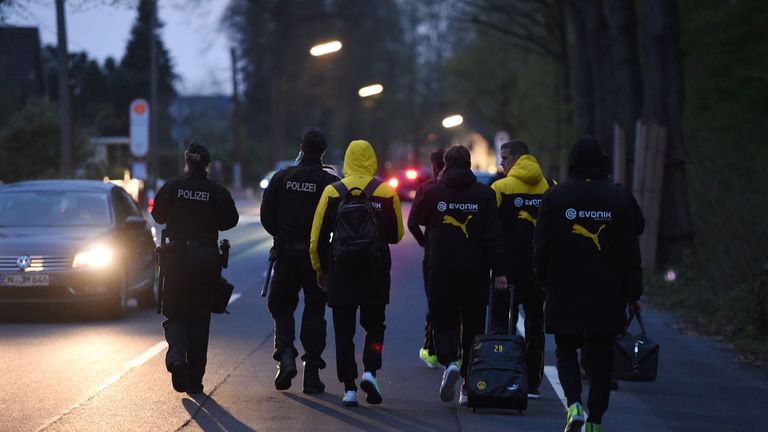 Police escort Dortmund's players after their team bus was damaged by three explosions