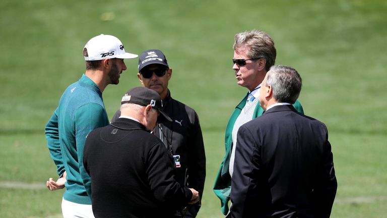 AUGUSTA, GA - APRIL 06:  Dustin Johnson (L) of the United States talks to Augusta National member Fred Ridley (2nd R) on the practice range prior to announ