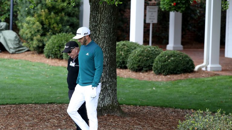 AUGUSTA, GA - APRIL 06:  Dustin Johnson of the United States walks with coach Butch Harmon to the practice range during the first round of the 2017 Masters