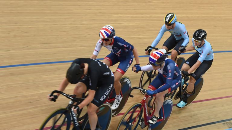 The Belgium (back) and Britain team (C) join hands during the women's madison final at the Hong Kong Velodrome during the Track Cycling World Championships