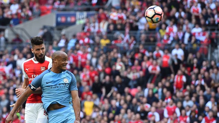 Arsenal's striker Olivier Giroud (L) vies with Manchester City defender Vincent Kompany