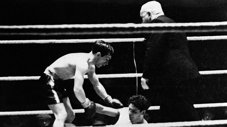 Scottish boxer Jackie Paterson, left, stops to aid his opponent, Mexican Manuel Ortiz, after he fell towards the end the the match. Paterson lost on points