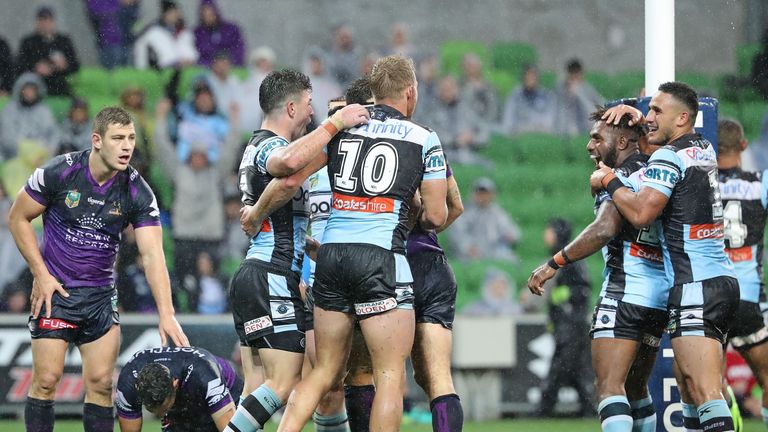 MELBOURNE, AUSTRALIA - APRIL 09:  James Segeyaro of the Sharks is congratulated by his teammates after scoring the match-winning try as Cameron Smith of th
