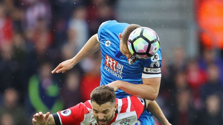 Jay Rodriguez of Southampton (L) and Simon Francis of AFC Bournemouth (R) battle to win a header during the Premier League clash