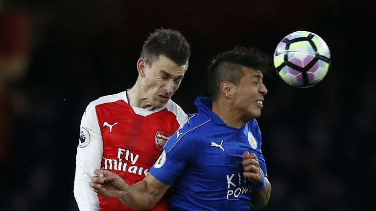 Leonardo Ulloa vies with Laurent Koscielny