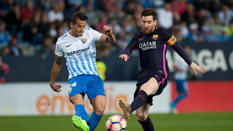 Malaga's defender Luis Hernandez (L) vies with Barcelona's Lionel Messi