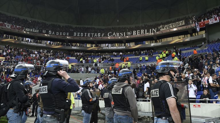 French police stand guard after Besiktas' and Lyon's fans fought before the UEFA Europa League first leg quarter final football match between Lyon (OL) and