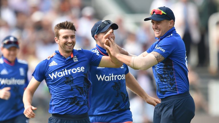 England's Mark Wood (L) celebrates with Joe Root and Jason Roy (R) after taking the wicket of Pakistan's Shoaib Malik (not pictured) during play in the sec