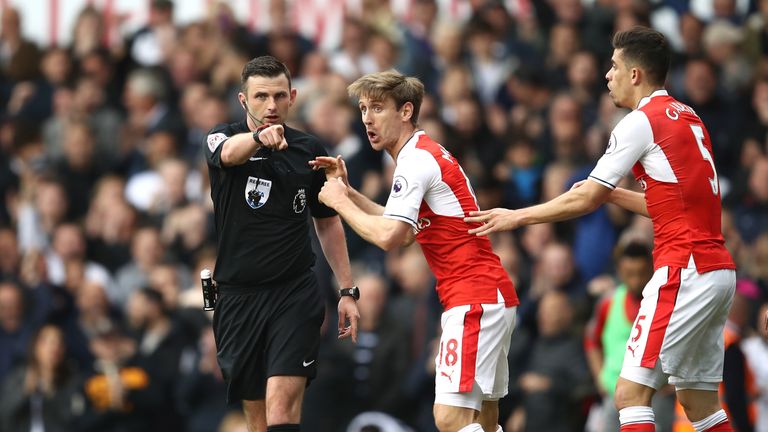 Referee Michael Oliver points to the spot to award Tottenham Hotspur a penalty after Gabriel of Arsenal fouled Harry Kane of Tottenham