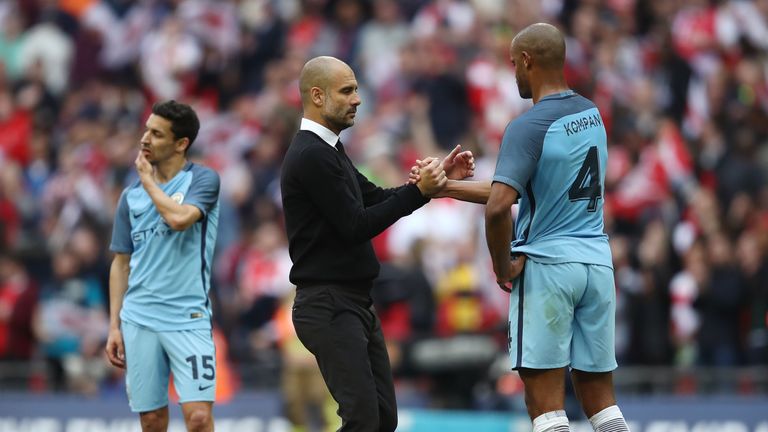LONDON, ENGLAND - APRIL 23:Vincent Kompany (R) of Manchester City is consoled by manager Josep Guardiola (C) during the Emirates FA Cup Semi-Final match be