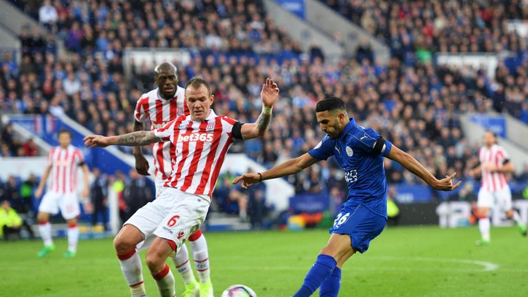 Riyad Mahrez of Leicester City (R) shoots as Glenn Whelan of Stoke City (L) attempts to block