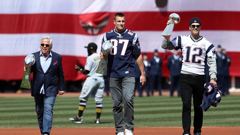 Robert Kraft, Rob Gronkowski and Tom Brady walk onto the field at Fenway with Vince Lombardi trophies
