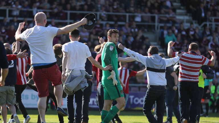 Northampton Town's goalkeeper Adam Smith looks on as Sheffield United supporters celebrate promotion to the Sky Bet Championship